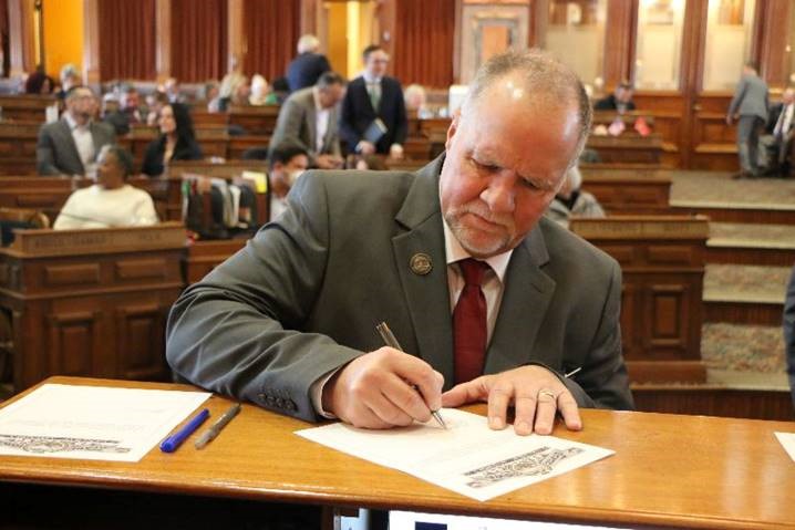 Brad Sherman signing a document in the Iowa House
